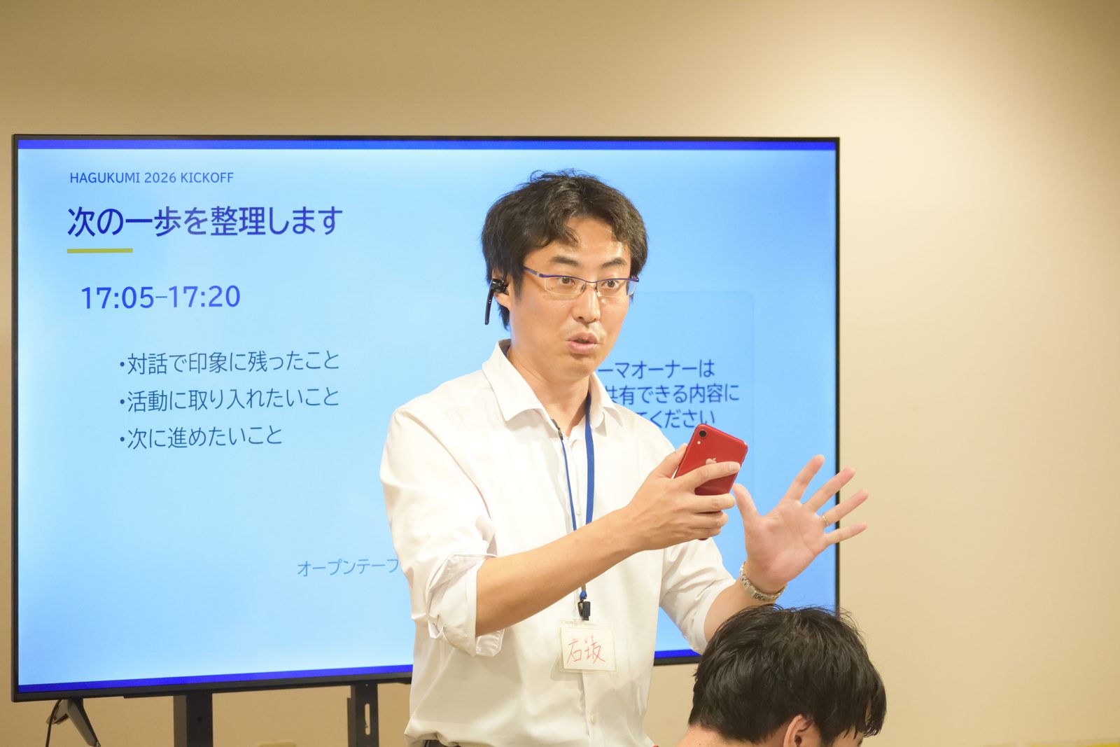 「次の一歩を整理します」のスライドの前で話す当社代表